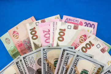 different hryvnias and dollars on a blue background. Business concept.