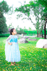 Portrait of cute smiling little girl in princess costume standing in the park