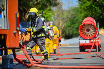 firefighters with oxygen mask working on the road accident