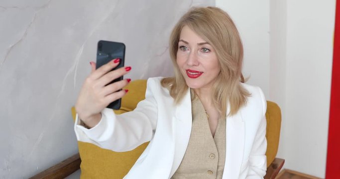adult woman blonde takes pictures of herself on the phone