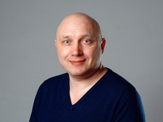 Portrait of a bald cheerful man on a gray background