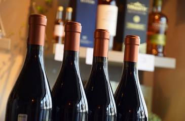 Wine bottles on wooden shelf in wine store