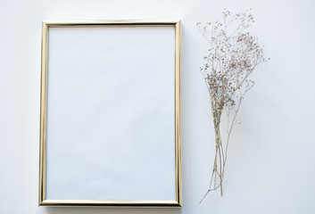 Gold blank frame on white background with flower. Minimalistism background. Mock up frame. Summer or travel concept. Copy space