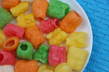 Colorful pipe fryums in a white plate, Indian fried snack 