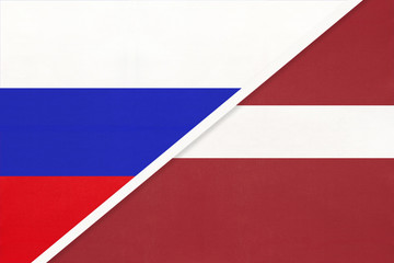 Russia vs Latvia national flag from textile. Relationship and partnership between two countries.