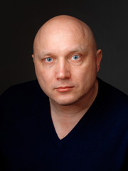 Portrait of a bald cheerful man on a black background