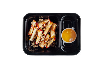Healthy lunch at workplace. Take away meals in black containers with cutlery on gray table