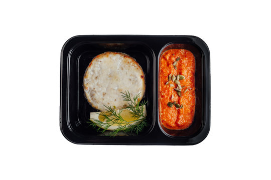 Healthy lunch at workplace. Take away meals in black containers with cutlery on gray table