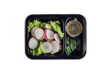 Healthy lunch at workplace. Take away meals in black containers with cutlery on gray table