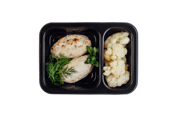 Healthy lunch at workplace. Take away meals in black containers with cutlery on gray table