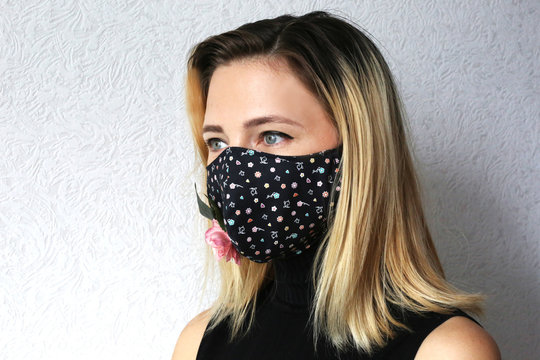 Woman wearing face mask decorated with flowers. Stylish handmade cotton mask. 