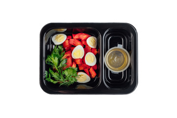 Healthy lunch at workplace. Take away meals in black containers with cutlery on gray table