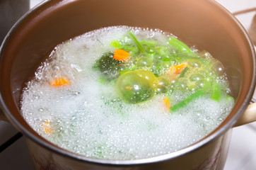 Vegetables boiling in the pot. Healthy food. Vegan recipes. Broccoli, carrots and green beans.