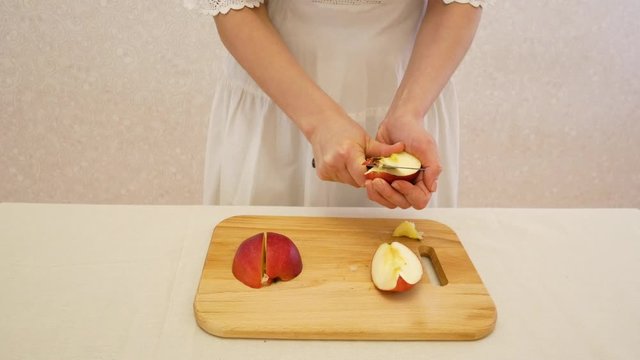 The girl chop and brush the red apple.