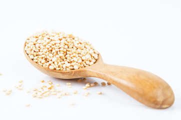 quinoa seeds in wooden spoon.