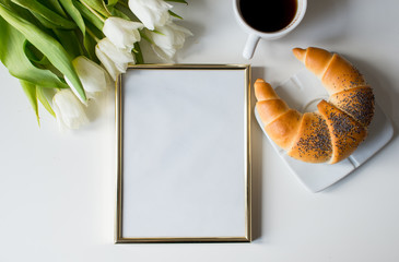 Coffee croissant mock up frame top view breakfast morning work office. Minimal styled flat lay isolated on white background. Feminine desk top view with white tulips, coffee, blank frame