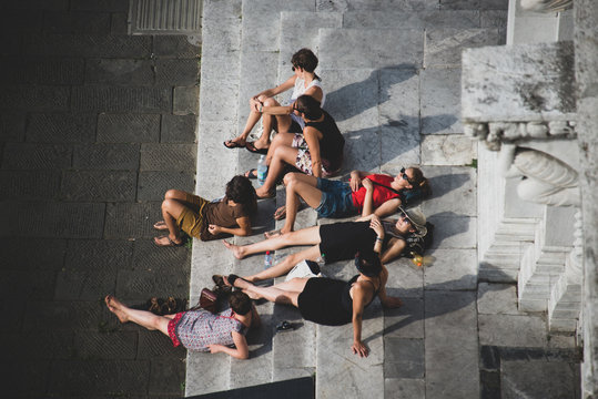 Gruppo di persone sdraiate sulle scale di una chiesa,  dall'alto, Lucca Italia Europa