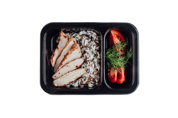 Healthy lunch at workplace. Take away meals in black containers with cutlery on gray table