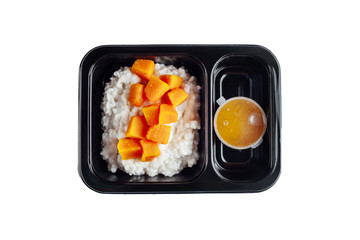 Healthy lunch at workplace. Take away meals in black containers with cutlery on gray table