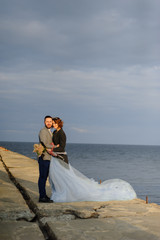 Fototapeta na wymiar Wedding photo session of a couple on the seashore. Blue wedding dress on the bride.