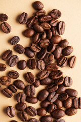 Arabica coffee beans close-up on a light brown background. For screensavers, roasters, and coffee sellers.