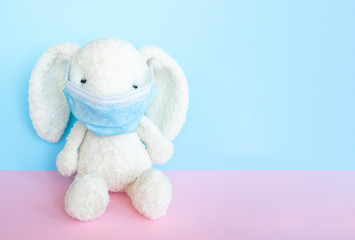Easter quarantine coronavirus concept, white bunny rabbit with face  protective mask on blue and...