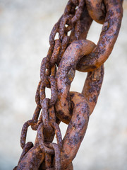 Old rusty anchor chain on a shingle beach