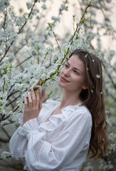 Beautiful girl in a flowered garden