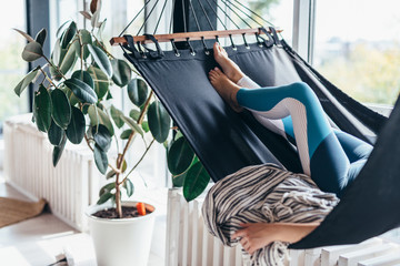 Woman is lying at home in a hammock and resting