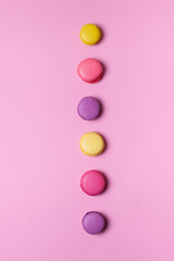 Fresh tasty macaron cake or macaroon on pink pastel background top view. 