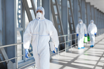 Virologists wearing protective hazmat suits making researches