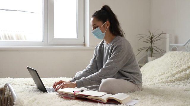 Coronavirus. Business woman working from home wearing protective mask. Working from home. Cleaning her hands with sanitizer gel. Concept hygiene