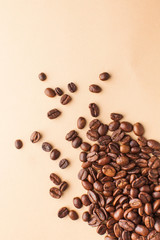 Coffee beans in the lower corner on a brown background. Vertical photo with space for text. For coffee houses and cafes.