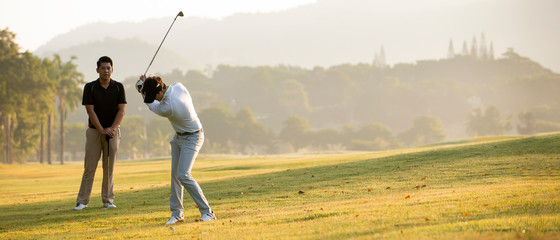 Asian man golfer playing golf with friend  at golf course