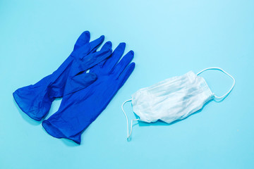 Protective medical mask, medical gloves and a sanitizer on a blue background. The first necessary protection for coronavirus. Covid-2019. Pandemic 2020.