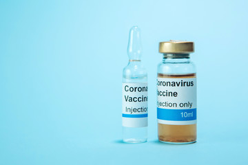 A test vaccine for coronavirus. A vial with a Vaccine from Covid-2019 on a blue background. A cure for the virus. Pandemic 2020. Experimental medicine.