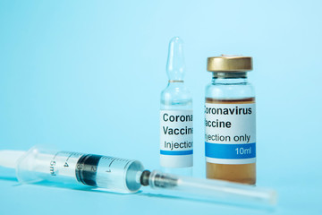 A test vaccine for coronavirus. A vial with a Vaccine from Covid-2019 on a blue background. A cure for the virus. Pandemic 2020. Experimental medicine.