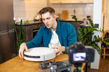 young caucasian blogger man show pros and cons of device at camera, he want to be useful for subscribers, share opinion