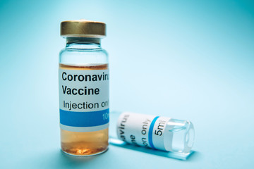 A test vaccine for coronavirus. A vial with a Vaccine from Covid-2019 on a blue background. A cure for the virus. Pandemic 2020. Experimental medicine.