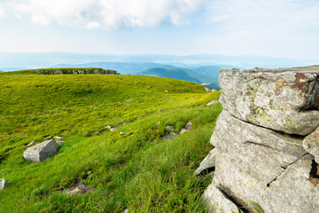 beautiful summer landscape in mountains. green grassy meadow on the hill side. view in to the...
