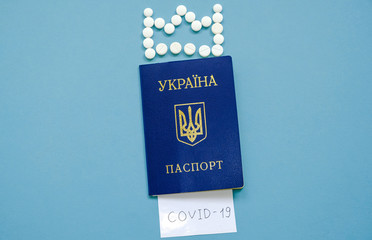 Ukrainian passport with the inscription Covid-19 and a crown of tablets