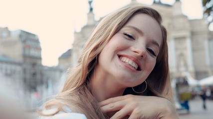 Close up view of sunshine young smiling charming woman with curly hair look at camera poses take selfie smile portrait happy summer face sunset beautiful lady outdoor cute