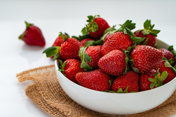 Close up of ripe red strawberries on white bowl