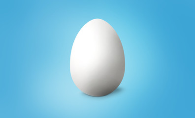 White Easter egg on blue pastel background. Happy Easter concept. 