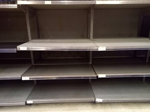 Emtpy shelfs in supermarket due to panic shopping because of Corona-Virus, Covid-19. Business and healthcare concept.