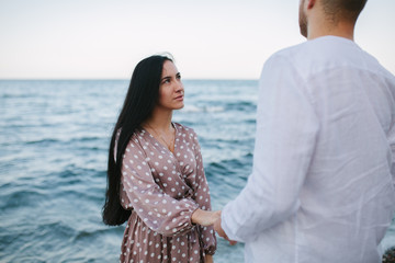 Girl holding a guy's hand on the beach