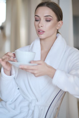 woman resting in a bathrobe at home