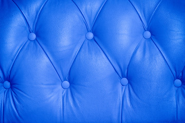 Blue background pattern of a chesterfield buttoned leather sofa