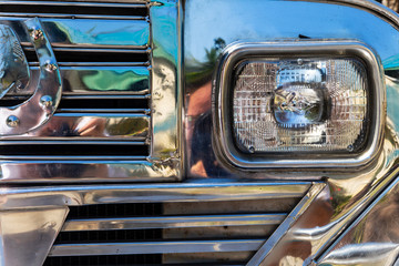 Chrome radiator grille and headlight of a filipino Jeepney in Manila, Philippines. A refurbished...