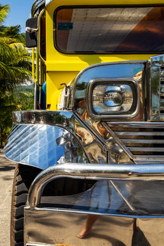 Close-up on the chrome radiator grille, headlight bumper and mud guard of a filipino Jeepney in Manila, Philippines. A refurbished bus for public transportation made from recycled US.military cars.
